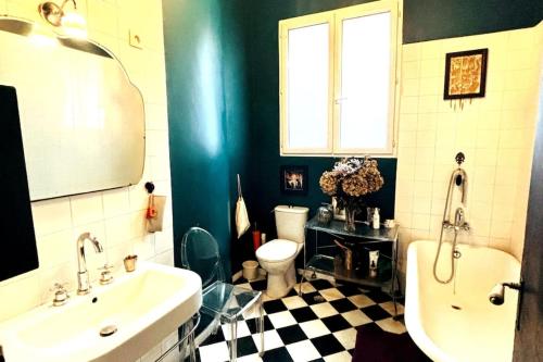 une salle de bain avec un lavabo, une baignoire et des toilettes dans l'établissement Central Paris Bohémien and Arty Apt, à Paris