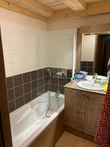 une salle de bain avec une baignoire et un lavabo dans l'établissement Duplex famille 10 à 12 personnes station les coches La plagne, à La Plagne Tarentaise