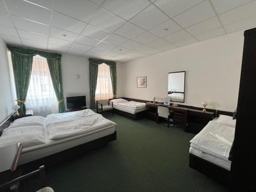 um quarto de hotel com duas camas e uma televisão em Hotel Omega Brno em Brno