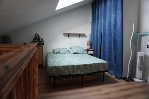 une chambre avec un lit et un rideau bleu dans l'établissement Au pied de l'étang LC Terre Occitane, à Port-Leucate