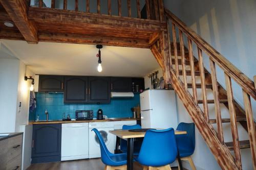 une cuisine avec une table et des chaises bleues dans l'établissement Au pied de l'étang LC Terre Occitane, à Port-Leucate