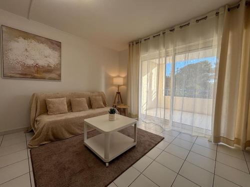 un salon avec un canapé et une table dans l'établissement T2 lumineux 4 pers, pisc,plag 2min, park priv,wifi, à Saint-Raphaël