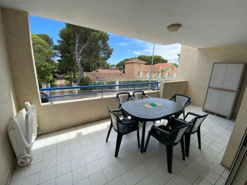 un balcon avec une table et des chaises et une grande fenêtre dans l'établissement T2 lumineux 4 pers, pisc,plag 2min, park priv,wifi, à Saint-Raphaël