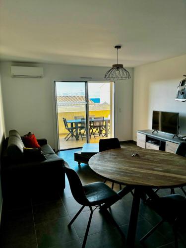 un salon avec une table et une salle à manger dans l'établissement Appartement Rossignol, à Saint-Florent