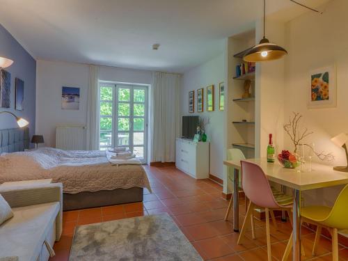 ein Schlafzimmer mit einem Bett und einem Tisch und Stühlen in der Unterkunft Feriendorf Rugana - Budget 1-Raum Appartement mit Terrasse A10 in Dranske