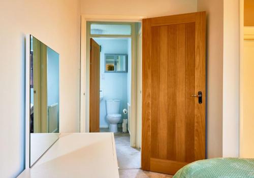 łazienka z toaletą i drewnianymi drzwiami w obiekcie Bluebirds Cottage - Light & Airy 2 Bed in Bourton! w mieście Bourton-on the-Water