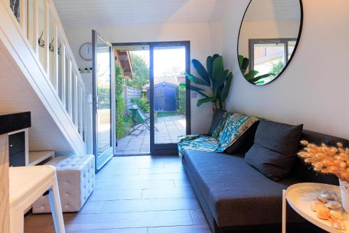 un salon avec un canapé et un miroir dans l'établissement Maison Kabâna - Welkeys, à Capbreton