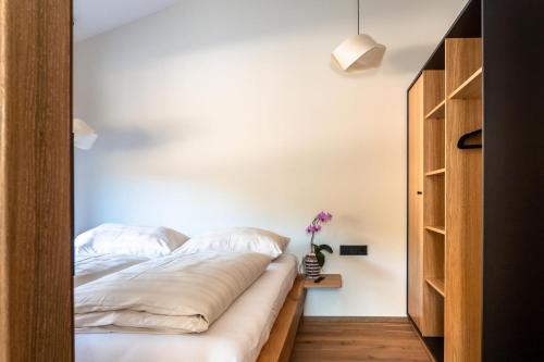 a bed in a room with a white wall at Alte Bildhauerei in Aurach bei Kitzbuhel