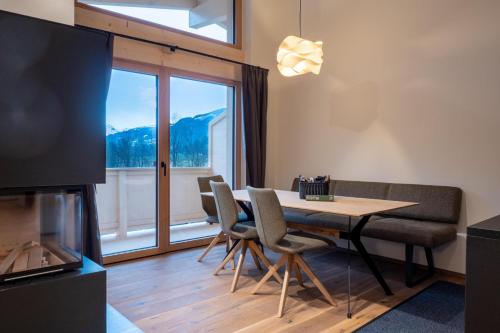 a dining room with a table and chairs and a large window at Alte Bildhauerei in Aurach bei Kitzbuhel