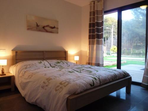 une chambre avec un lit et une grande fenêtre dans l'établissement Villa Cap Dramont, à Saint-Raphaël