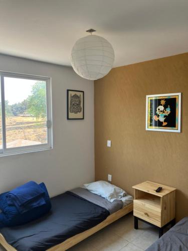 a bedroom with a bed and a window and a table at Departamento en Pátzcuaro in Pátzcuaro