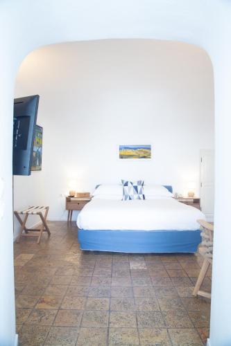 a bedroom with a large bed and a tv at Pantelia Suites in Fira