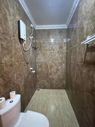 a bathroom with a white toilet and a shower at Ithaa Dhigurah Maldives in Dhigurah
