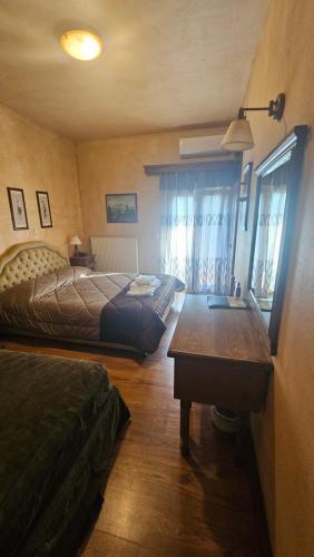 a bedroom with two beds and a table in it at Villa Virginia Hotel in Karpenision