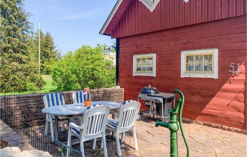 a table and chairs sitting outside of a red house at 2 Bedroom Lovely Apartment In Borgholm in Borgholm