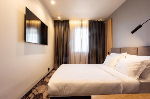 a bedroom with a white bed and a window at Kamengrad Hotel & SPA in Panagyurishte