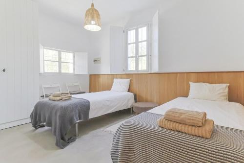 イスナハルにあるCasa Olivoのベッドが2つと窓が2つある寝室
