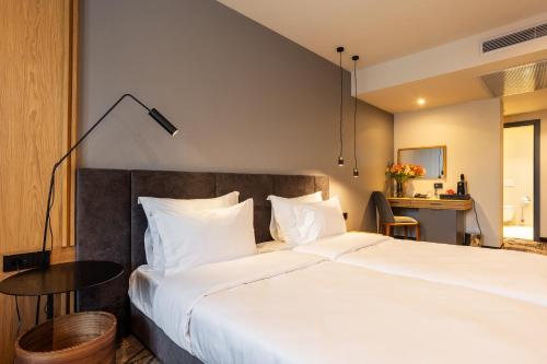 a bedroom with a large white bed and a table at Kamengrad Hotel & SPA in Panagyurishte