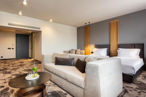 a hotel room with a couch and a bed at Kamengrad Hotel & SPA in Panagyurishte