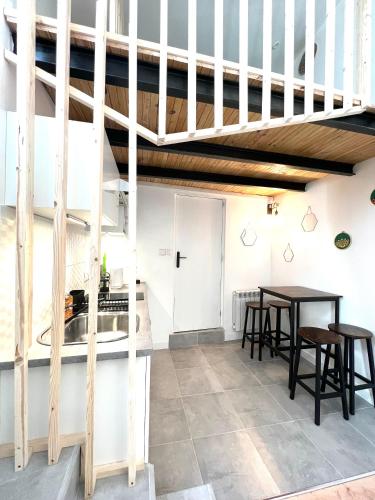 une chambre avec deux tables et un escalier dans l'établissement Jolie Mini Maison Lovely Tiny House, à Vitry-sur-Seine