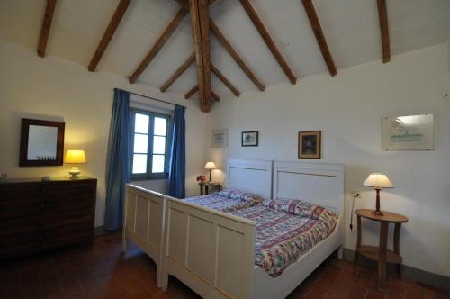 a bedroom with a bed and a dresser and a window at Petrolo in Bucine