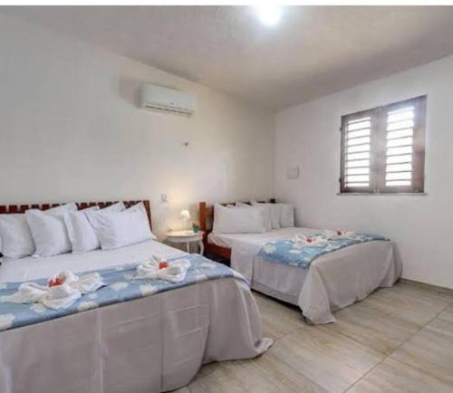 a bedroom with two beds and a window at Casa de Praia Aconchegante in Aquiraz