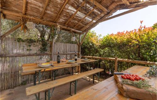 un patio con mesa de madera y bancos en 3 Bedroom Gorgeous Home In Orbicciano, en Monsagrati