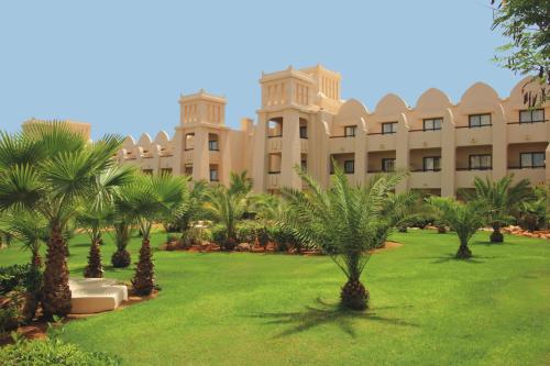 a large building with palm trees in front of it at Hotel Riu Touareg - All Inclusive in Curral Velho