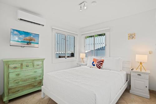 Un dormitorio blanco con una cama y dos ventanas. en Washington 49-Q, en Palm-Eagle Beach