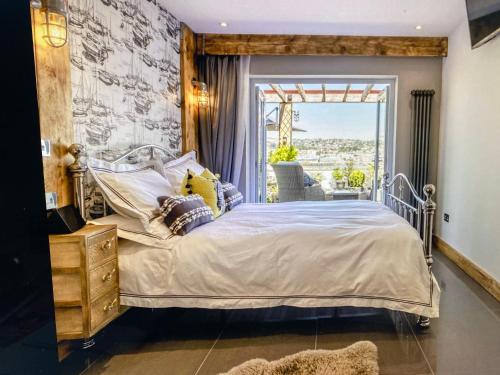 Un dormitorio con una cama y una ventana grande. en Con-Mar, en Shaldon