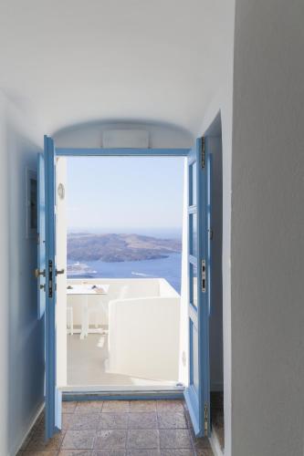 an open door to a room with a view of the ocean at Pantelia Suites in Fira