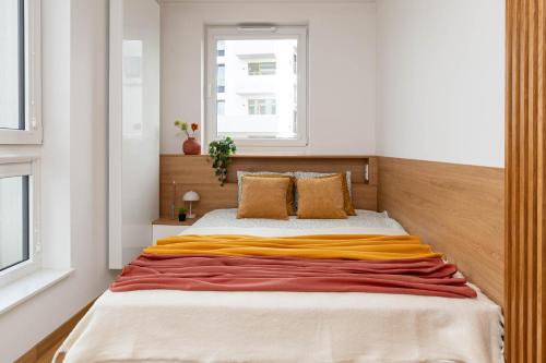 a bedroom with a bed with a yellow blanket on it at SuperApart Sternicza apt 43 in Warsaw
