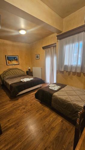 a bedroom with two beds and a window at Villa Virginia Hotel in Karpenision