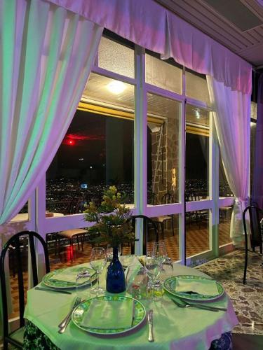 a table with a green table cloth and a vase with flowers at HOTEL VALLEVERDE in Corbara