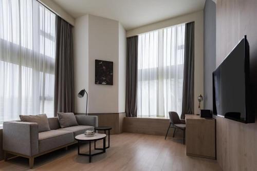 a living room with a couch and a flat screen tv at Atour S Hotel Shanghai Hongqiao Center Aegean-Late night Congee in Shanghai
