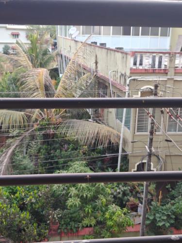 a view from a window with palm trees and buildings at Sri Vidya Palace in Udupi