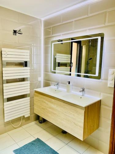 une salle de bain avec un lavabo et un miroir dans l'établissement Maison familiale vue mer au calme 3 etoiles Villa Rose, à Préfailles