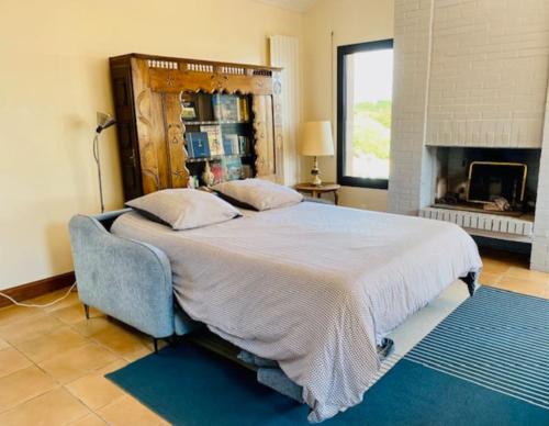 - une chambre avec un grand lit et une cheminée dans l'établissement Maison familiale vue mer au calme 3 etoiles Villa Rose, à Préfailles