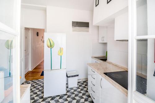 a kitchen with white cabinets and a checkered floor at Lisbon Guesthouse in Lisbon