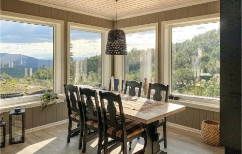 a dining room with a table and chairs and windows at Nice Home In Rauland With House A Mountain View in Rauland