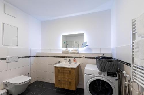 a bathroom with a washing machine and a sink at Yoga-Oase am Krakower See - Erdgeschoss mit Terrasse, Kamin & Sauna in Krakow am See