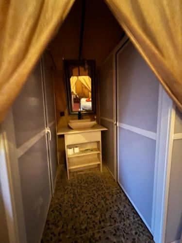 a bathroom with a vanity and a mirror in a room at Khadija Desert Camp in Merzouga