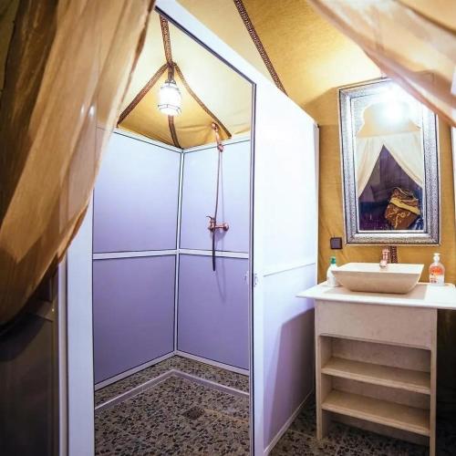 a bathroom with a shower and a sink at Khadija Desert Camp in Merzouga