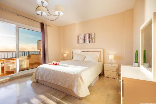 a bedroom with a bed and a large window at Residencial Playa de La Arena in Puerto de Santiago