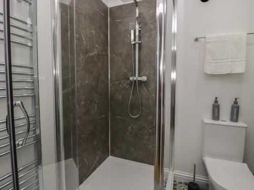 a shower with a glass door in a bathroom at Beechgrove Manor in Workington