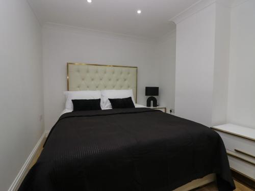 a bedroom with a large bed with black sheets and pillows at Beechgrove Manor in Workington