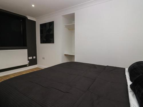 a bedroom with a large bed and a flat screen tv at Beechgrove Manor in Workington