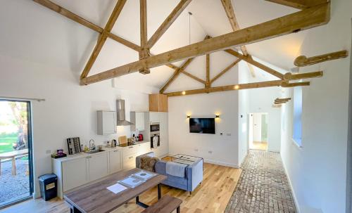 a kitchen and living room with wooden ceilings and a table at Beaumont Mews in St. Albans