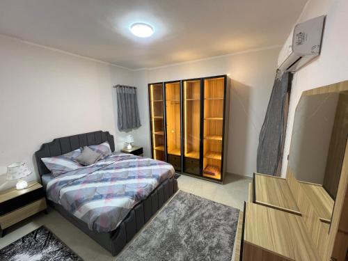 a bedroom with a bed and a dresser at Pyramid Heights Apartments in Cairo
