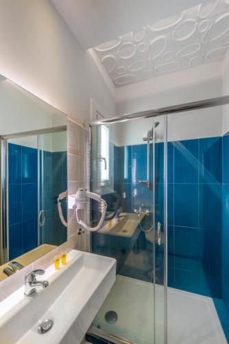 a bathroom with a sink and a glass shower at Ethrion in Ermoupoli